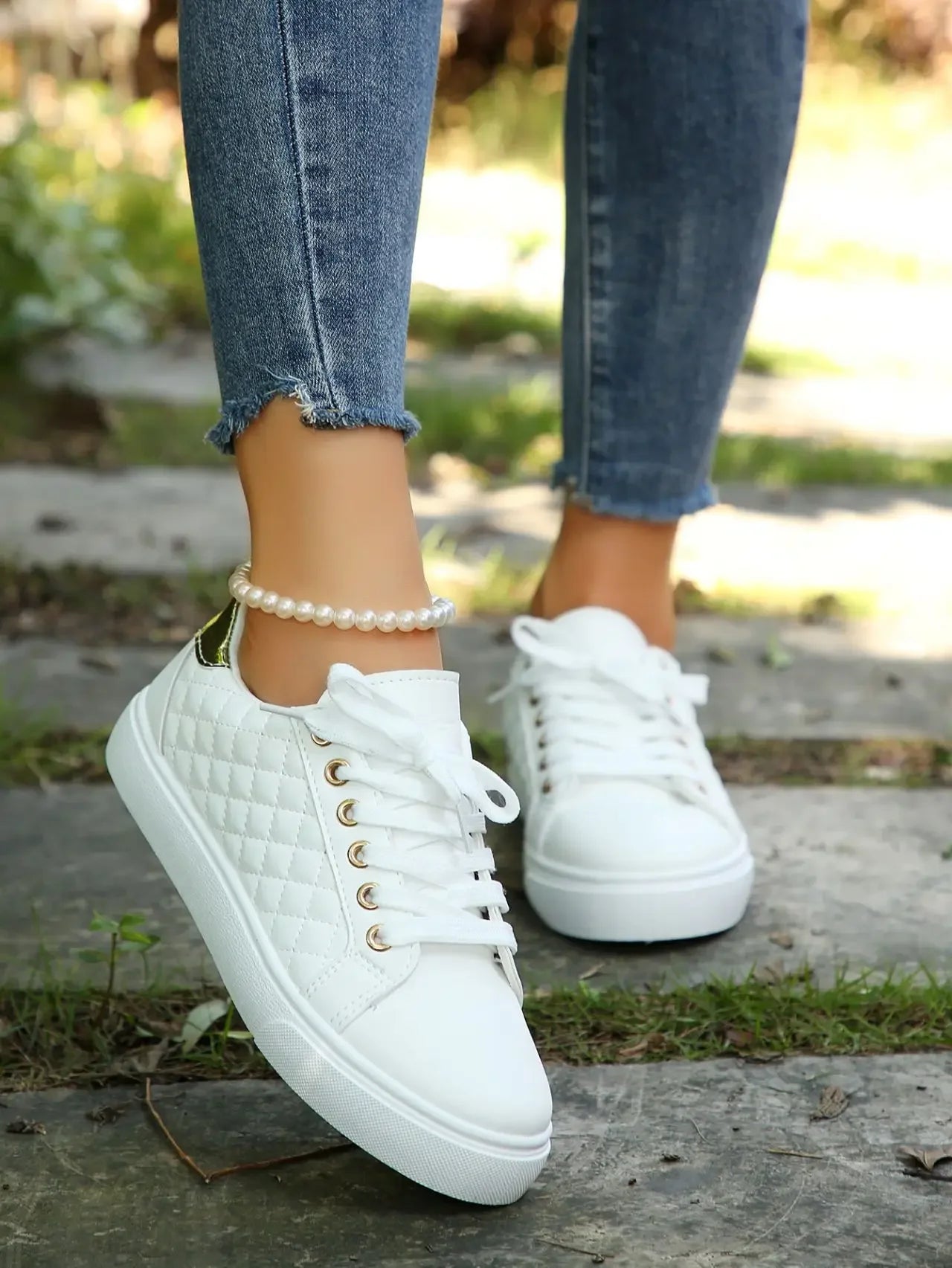 White quilted lace-up platform sneakers with gold eyelets, angled side and heel.