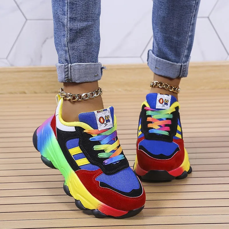 Pair of colorful platform sneakers with multicolor uppers and chunky soles, worn with denim