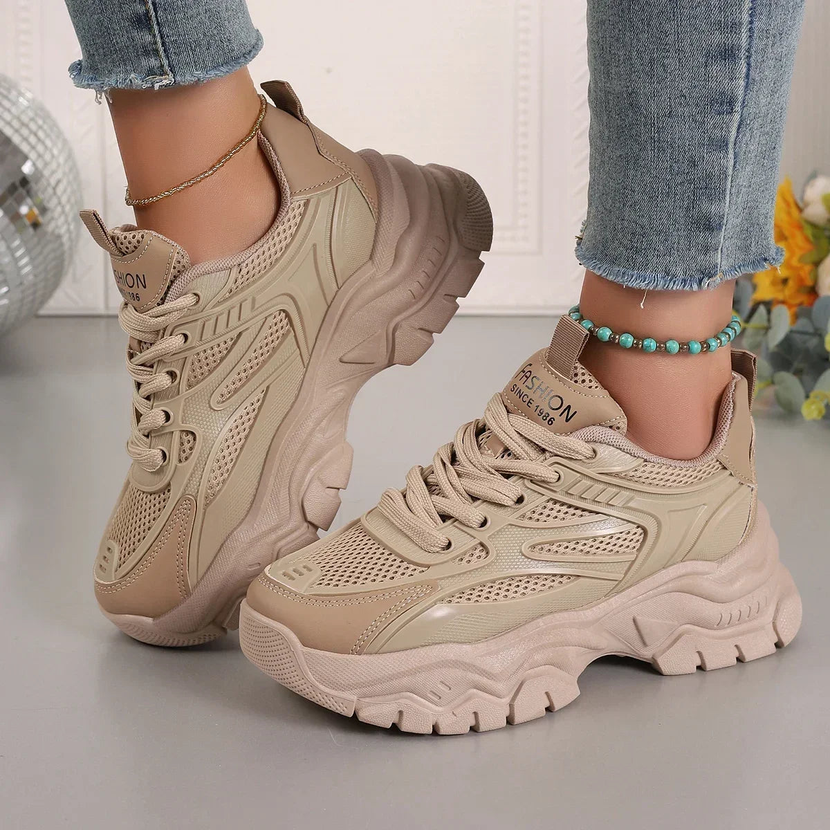 Beige chunky platform sneakers with lace-up mesh panels and ridged sole