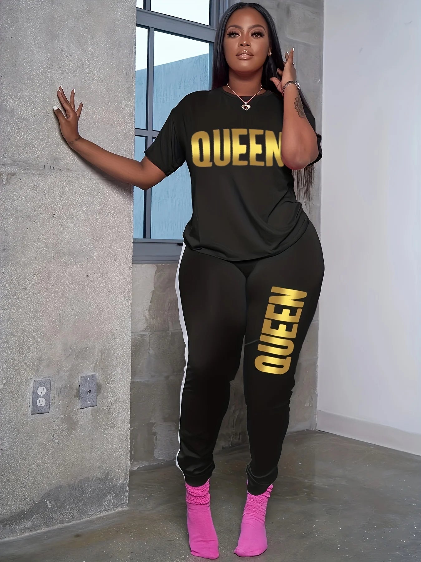 Black plus-size T-shirt and jogger set with yellow QUEEN print on chest and leg.