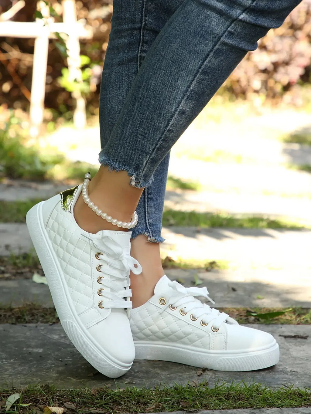 White quilted lace-up platform sneakers with gold eyelets, low side view.