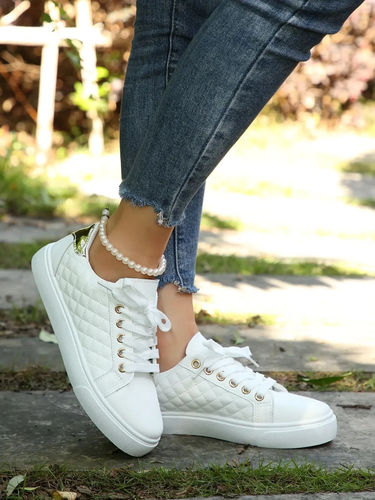 White quilted lace-up platform sneakers with gold eyelets, low side view.