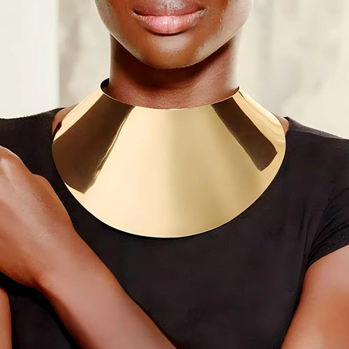 Gold-toned punk collar choker with exaggerated curved metal plates on a model’s neck.