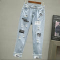 Light-wash ripped denim jeans with distressing and “DVI” cuff patch