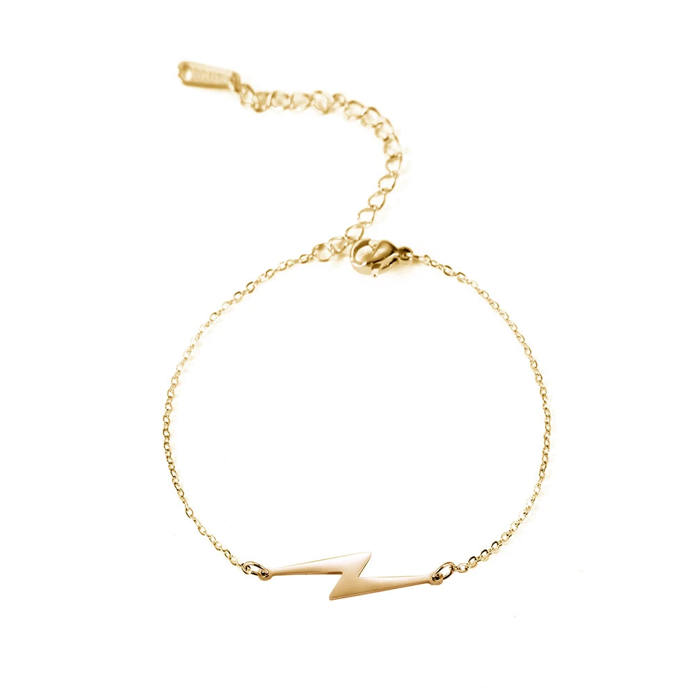 Gold tone lightning charm bracelet with linked chain and white lightning bolt pendant.