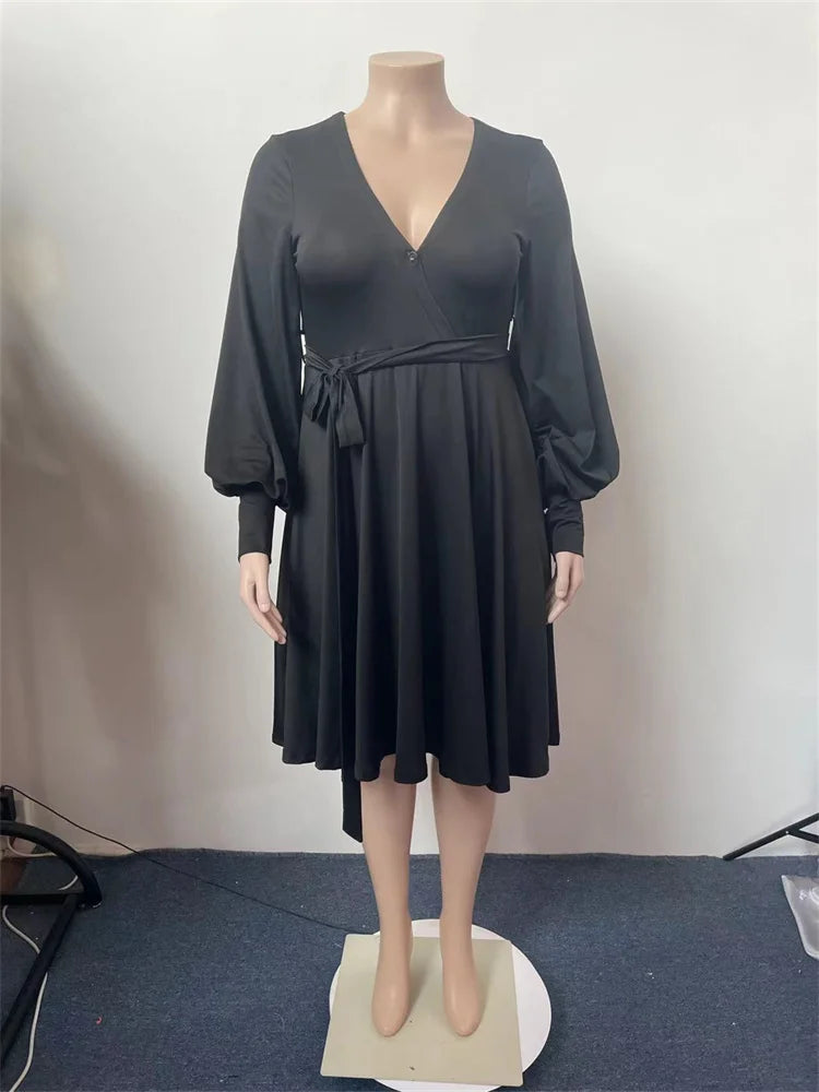 Dark plus size V-neck dress with ruched waist and flared pleated skirt