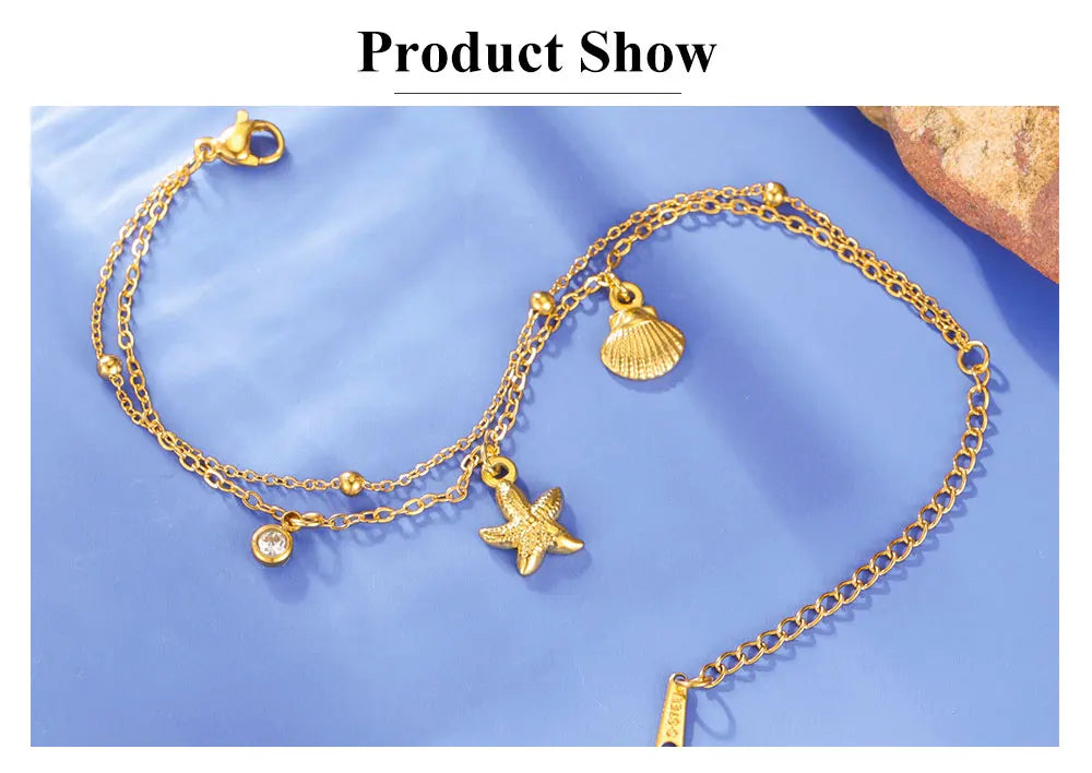 Gold-tone starfish and seashell charm bracelet set with round gem and clasp