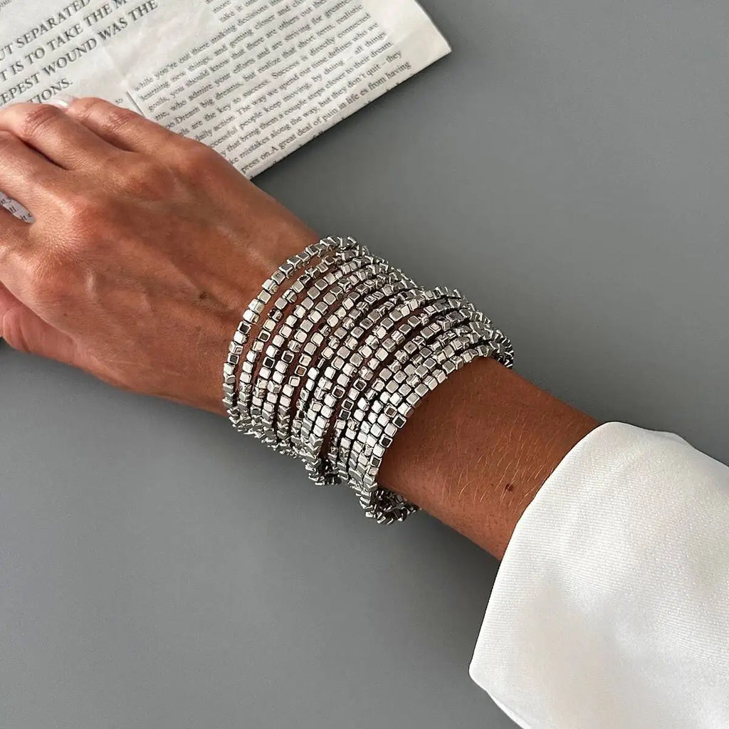 Silver-tone wide beaded cuff bracelet with stacked square bead bands.