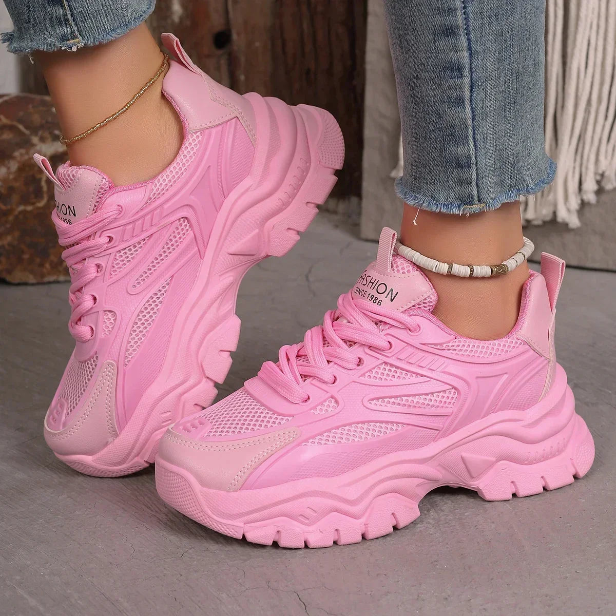 Pink chunky platform sneakers with lace-up mesh upper and thick ridged sole
