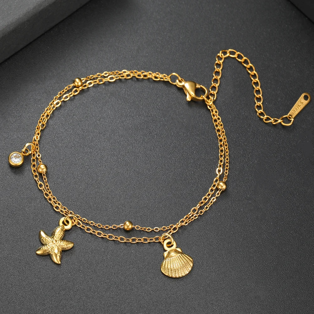 Gold-tone starfish and seashell charm bracelet with round gem accents