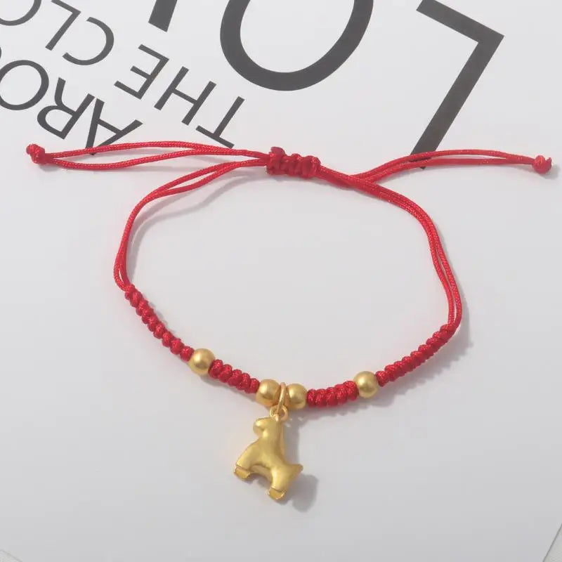 Red rope bracelet with gold beads and a gold horse charm