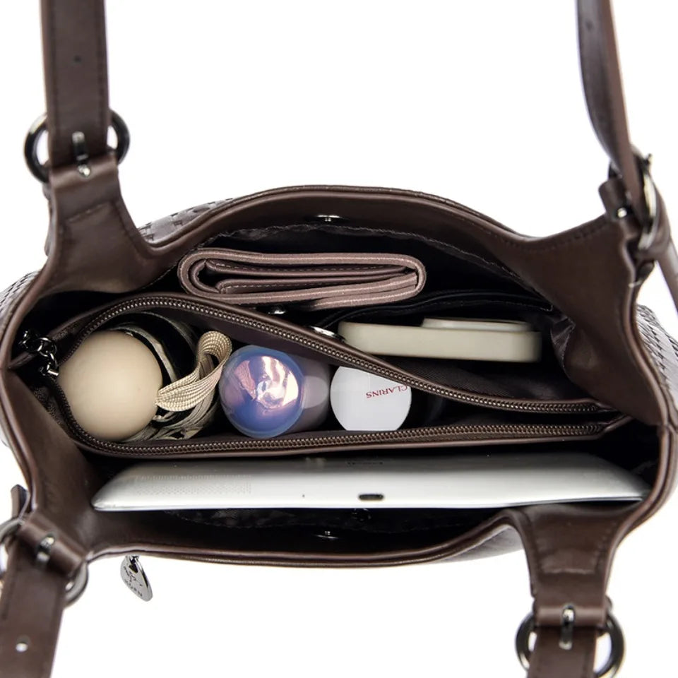 Brown leather shoulder bag open interior with zipper pockets and hanging strap