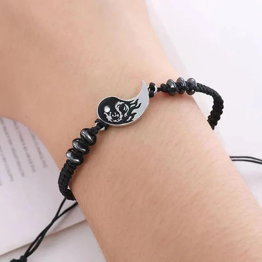 Black cord bracelet on wrist with yin-yang dragon moon pendant and bead stations