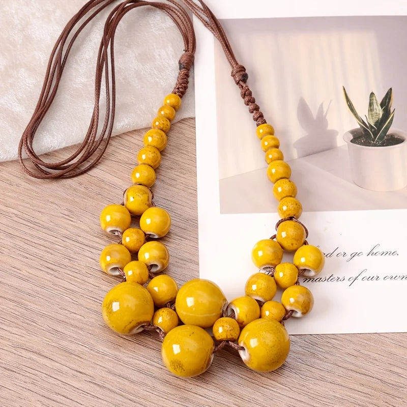 Beaded pendant necklace with yellow beads on brown rope cord and clustered drop pendant