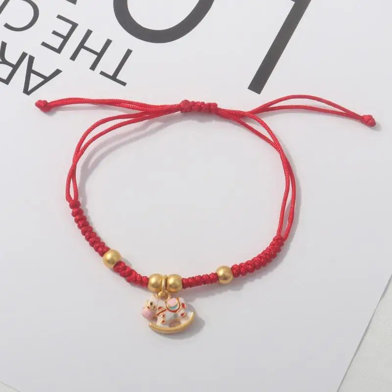Red rope bracelet with gold beads and a round gold horse pendant