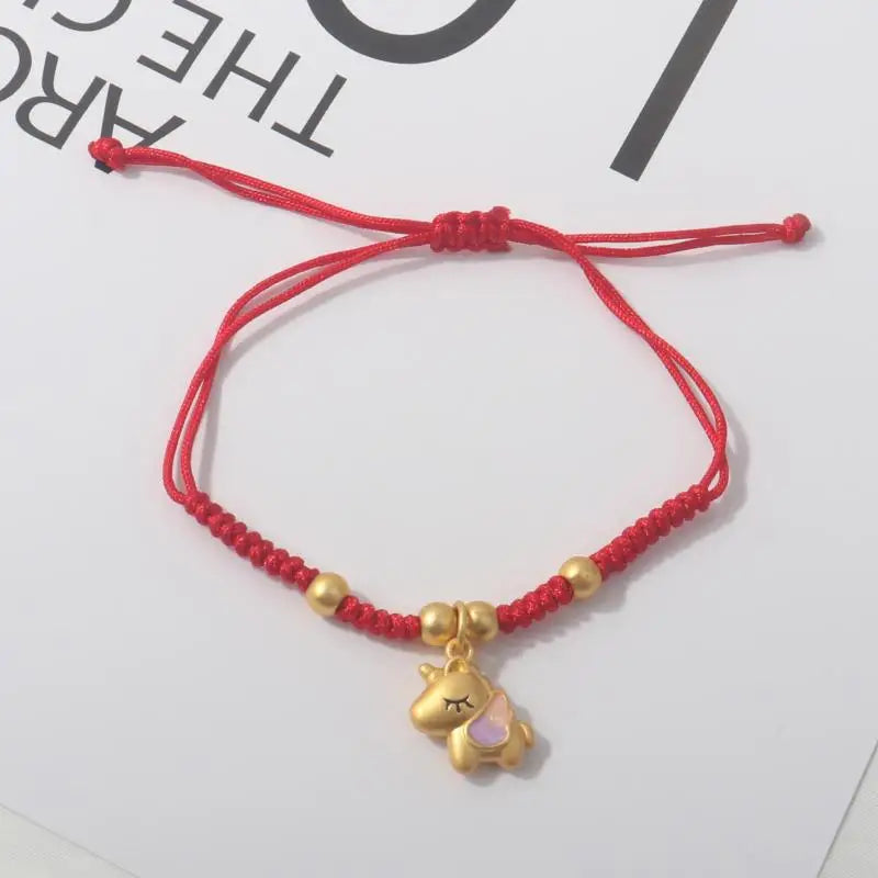 Red rope bracelet with gold beads and a gold cat-like horse charm