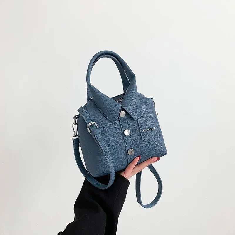 Square PU leather crossbody bag in blue with top handles and adjustable shoulder strap