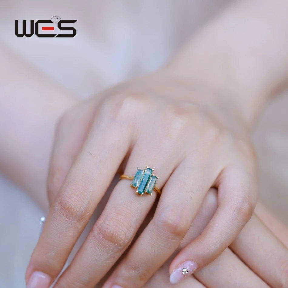 Moss agate three-stone ring on hand, green rectangular stones in gold setting