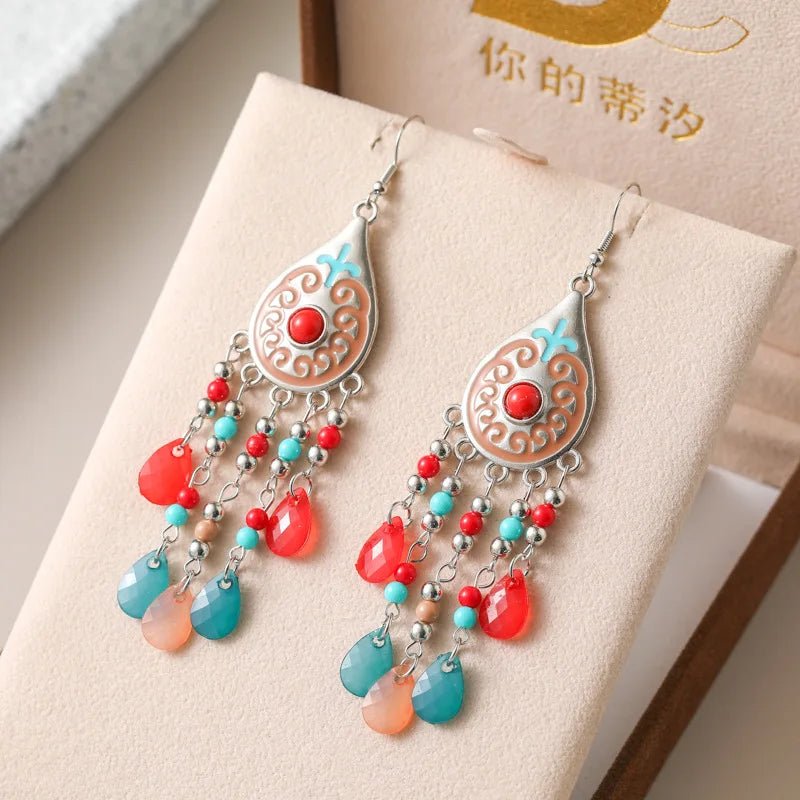 Red and turquoise teardrop bead tassel dangle earrings with ornate filigree and silver hooks