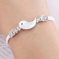 White cord bracelet on wrist with silver yin-yang dragon moon pendant and bead stations