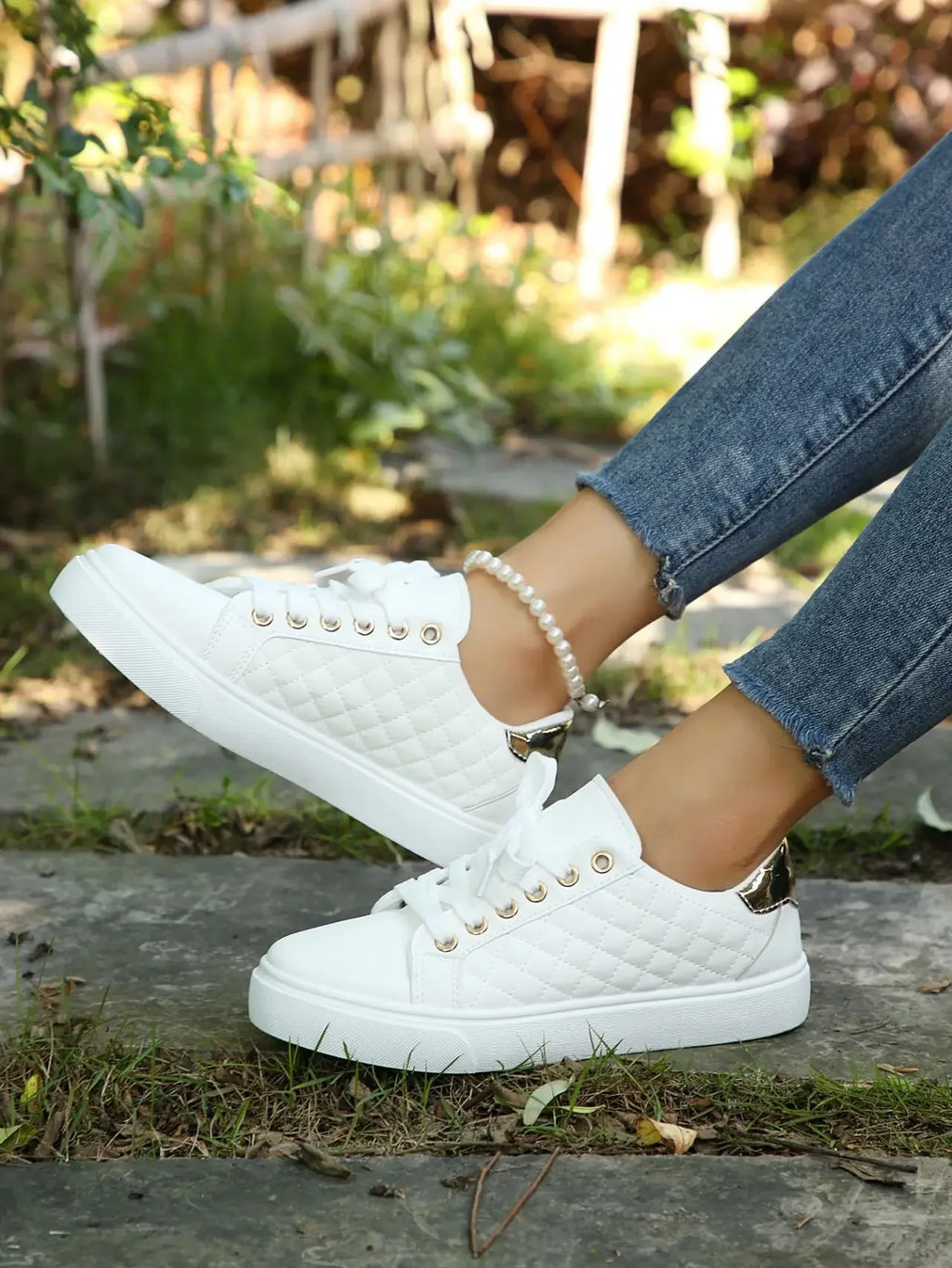 White quilted lace-up platform sneakers with gold eyelets, angled toe view.