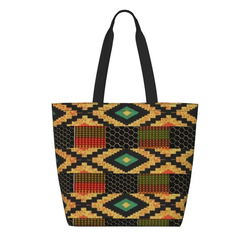 Canvas tote bag with black, gold, green, and red interlocking diamond pattern and black handles