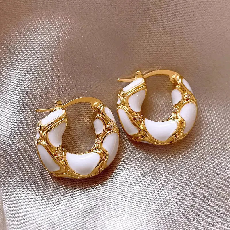 White enamel U-shaped hoop earrings with gold-tone rim and small bead accents