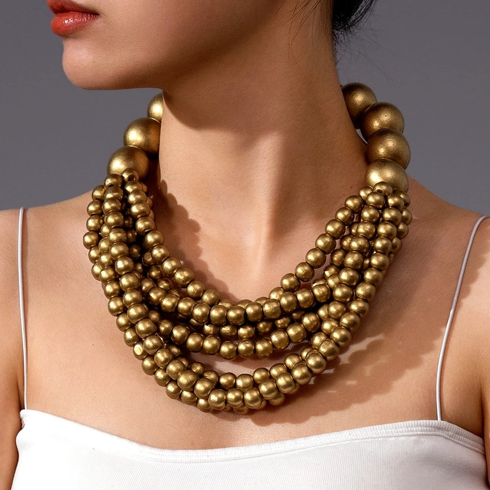 Multi-layer wooden beaded necklace with shiny gold-tone round beads and bold drape
