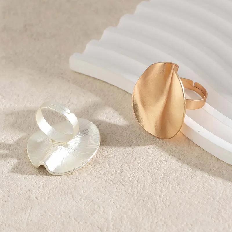 Gold-tone and silver-tone open adjustable rings with oval cuff tops, side view