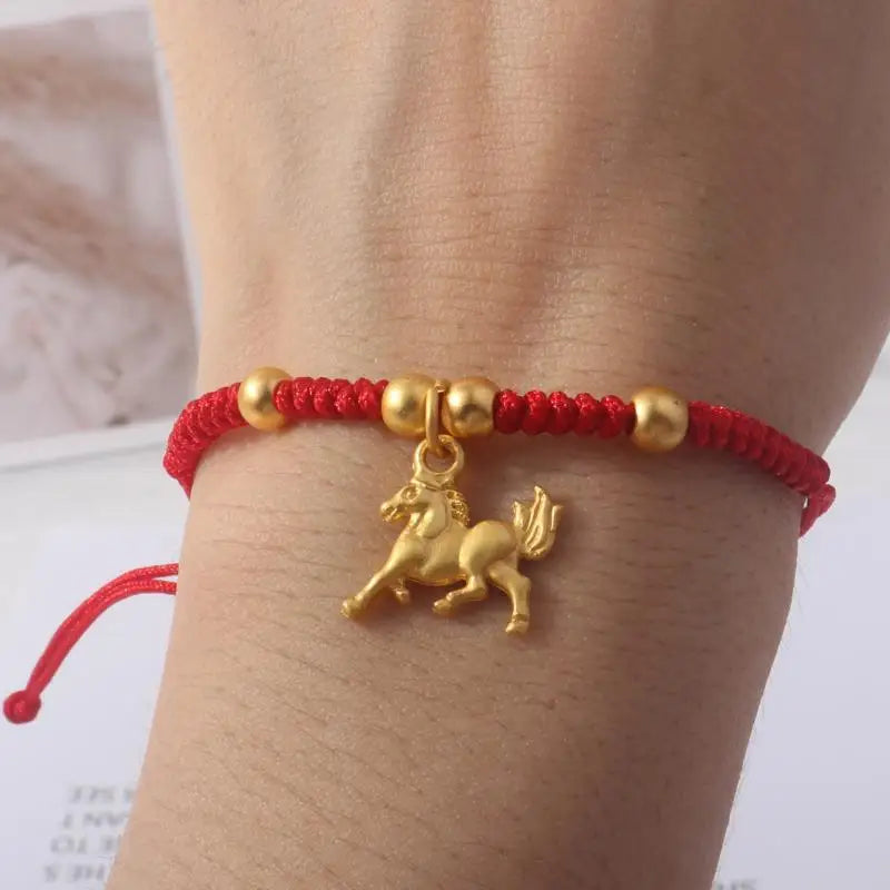 Red rope bracelet with gold horse charm and three gold spacer beads