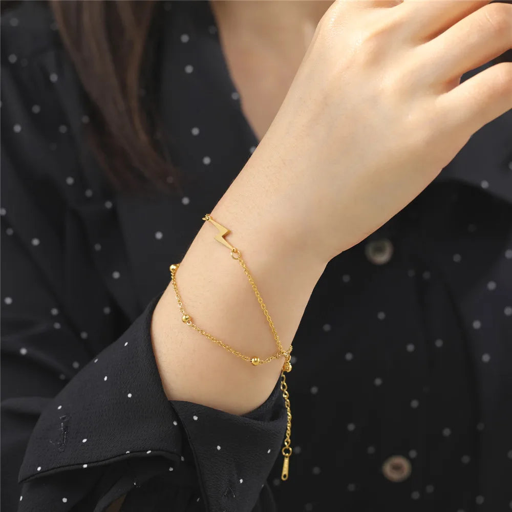 Gold-tone chain lightning bolt charm bracelet on wrist