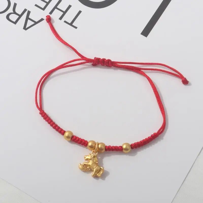 Red rope bracelet with gold beads and a gold horse charm
