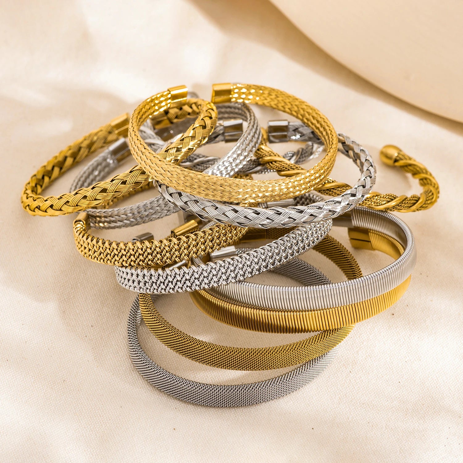 Set of gold and silver open-end woven bangles with textured mesh and cuff ends