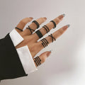 Black chain-link knuckle ring with geometric link design, worn on finger