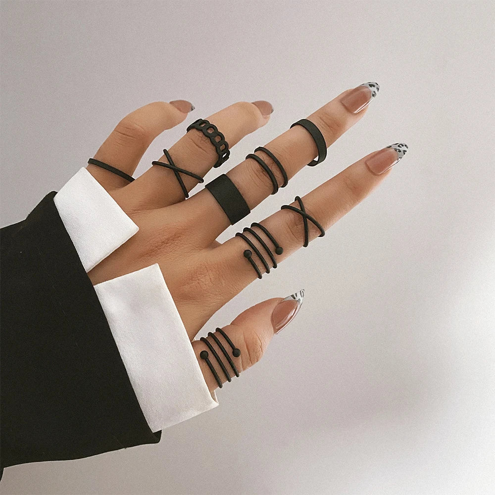 Black chain-link knuckle ring with geometric link design, worn on finger