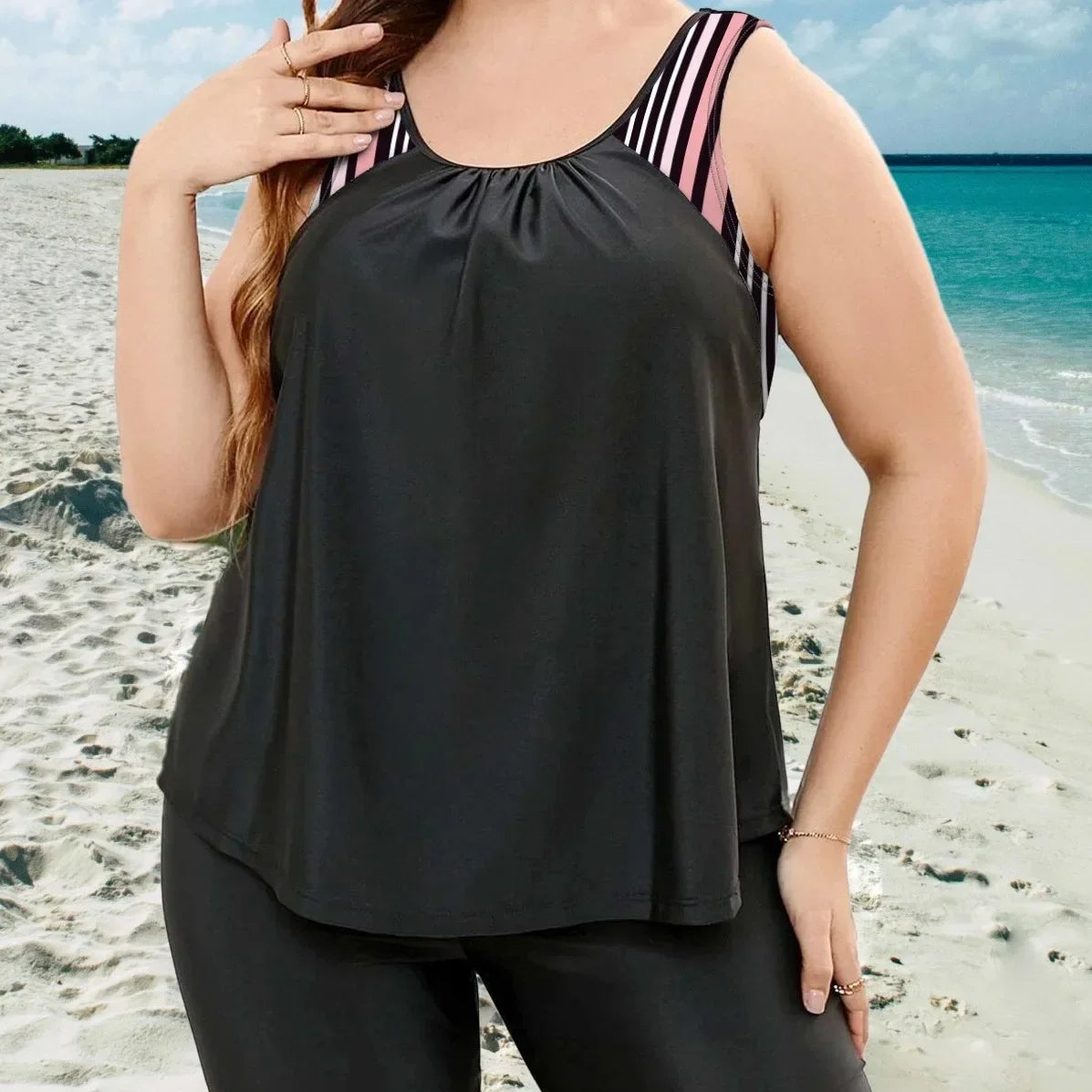Black tankini top with matching swim shorts, striped detail on shoulder strap