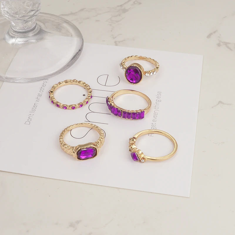 Gold-tone purple crystal rings on display card, showing multiple styles